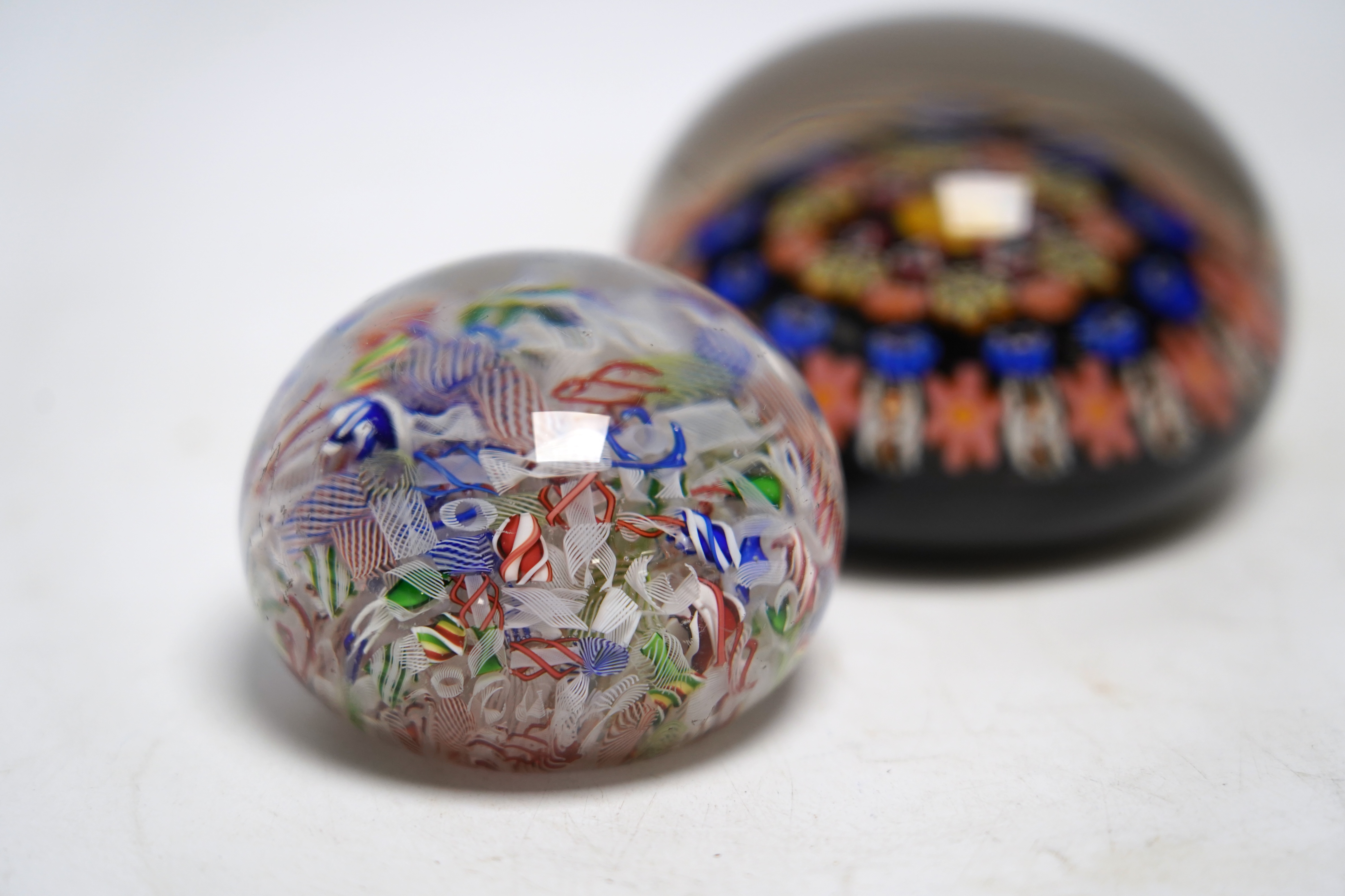 A mid 19th century French scattered cane paperweight and another, largest 8cm diameter